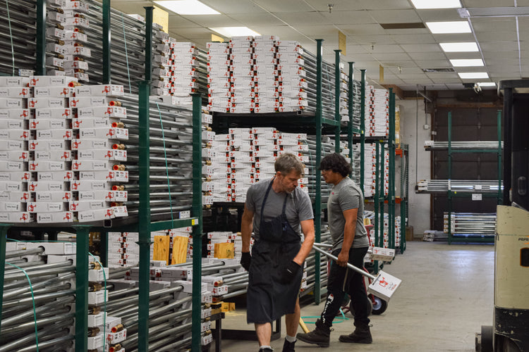 Merrill Manufacturing warehouse with employees handling yard hydrant components and packaged inventory.